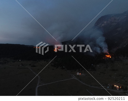 Aerial panoramic view of a forest fire at night, heavy smoke causes air pollution, and fire in full blaze. Natural disaster epic drone cinematic shot. Aerial panoramic view of a forest fire at night, heavy smoke causes air pollution, and fire in full blaze. Natural disaster epic drone cinematic shot. 92520211