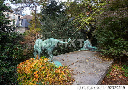 2 bronze lions - sculptures in amazing nature of Garden of Plants in Paris 2 bronze lions - sculptures in amazing nature of Garden of Plants in Paris 92520349