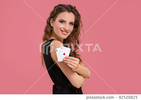 Young woman holding two aces in hand against on pink background 92520825