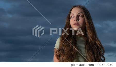 teen girl with long curly hair on sky background with copy space teen girl with long curly hair on sky background with copy space 92520930