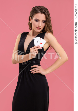 Young woman holding two aces in hand against on pink background 92520935