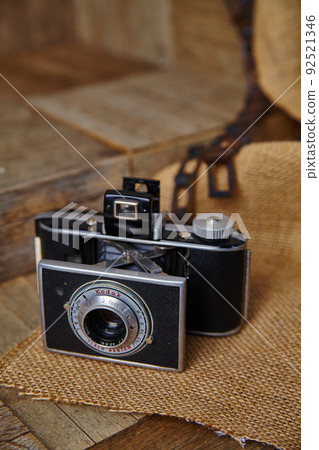 Antique film camera sitting on burlap cloth on a wooden surface Antique film camera sitting on burlap cloth on a wooden surface 92521346