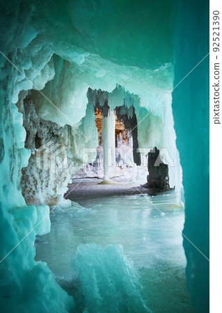 Large icicle in ice cave with vibrant blue and green colors 92521390
