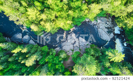 Aerial looking straight down over majestic river with cascades and lush green forest Aerial looking straight down over majestic river with cascades and lush green forest 92521424