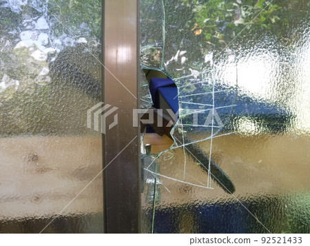 Glass window broken by a thief 92521433