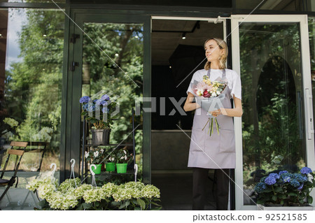 Business Woman near flower shop door. 92521585