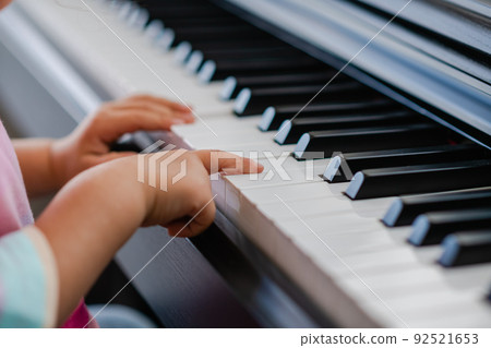 Hands of little girl playing piano, selective focus Hands of little girl playing piano, selective focus 92521653
