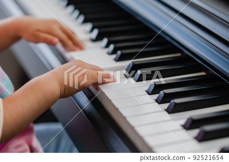 Hands of little girl playing piano, selective focus Hands of little girl playing piano, selective focus 92521654
