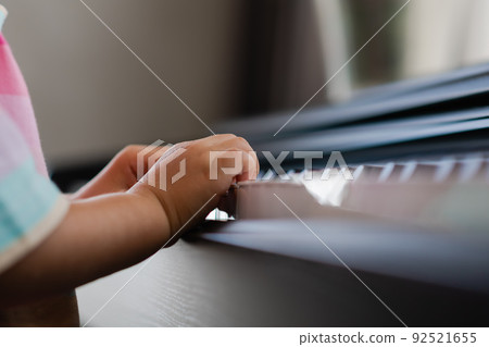 Hands of little girl playing piano, selective focus Hands of little girl playing piano, selective focus 92521655