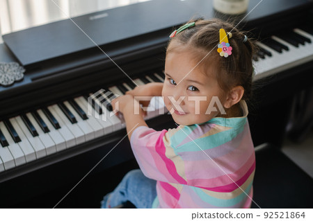 Little asian girl is happy playing the piano. Little asian girl is happy playing the piano. 92521864