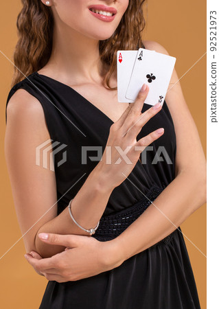 Beautiful brown-haired woman holding two aces as a sign for poker game, gambling and casino 92521973