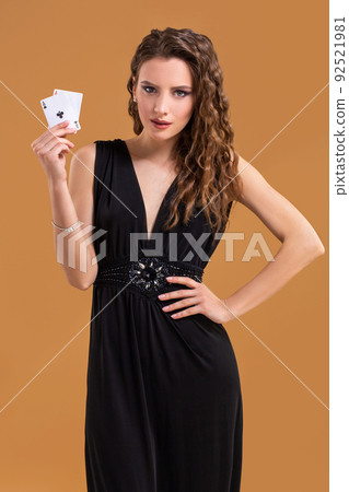 Beautiful brown-haired woman holding two aces as a sign for poker game, gambling and casino 92521981