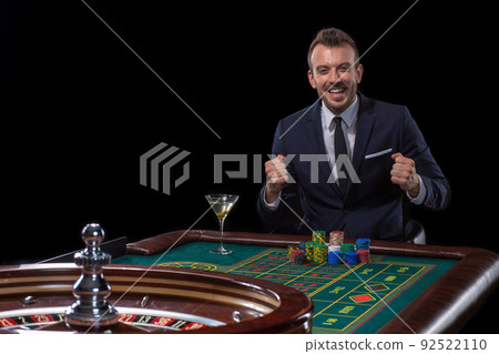 Gambler stakes playing at the roulette table. Risky entertainment of gambling 92522110