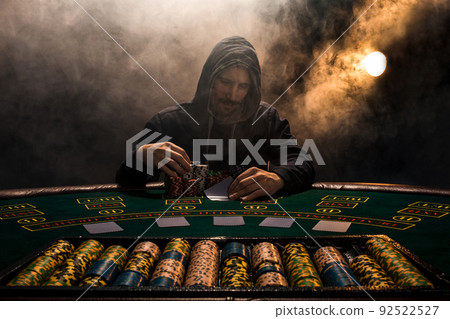 Portrait of a professional poker player sitting at pokers table 92522527