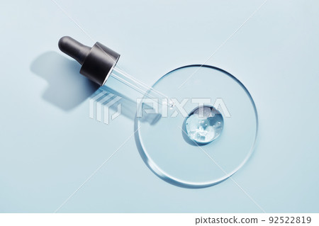 Pipette with sample of gels cosmetic product in petri dish on blue background, hard shadows 92522819