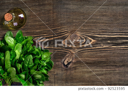 Spinach baby leaves on wooden background. Top view. Copy space Spinach baby leaves on wooden background. Top view. Copy space 92523595
