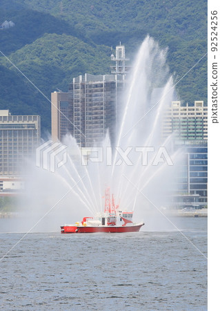 在神戶市容的背景下,一艘消防船用高壓水砲歡迎一艘大型客船抵達神戶港 在神戶市容的背景下,一艘消防船用高壓水砲歡迎一艘大型客船抵達神戶港 92524256