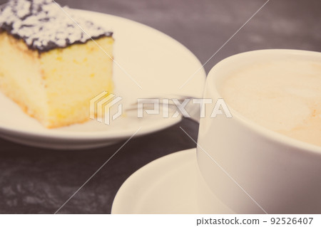 Cup of white coffee and fresh baked cheesecake. Delicious dessert Cup of white coffee and fresh baked cheesecake. Delicious dessert 92526407