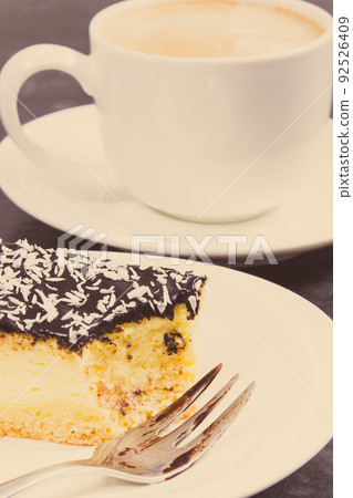 Fresh baked cheesecake and cup of coffee with milk. Delicious dessert Fresh baked cheesecake and cup of coffee with milk. Delicious dessert 92526409