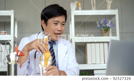 Professional specialized doctor talking with patient via medical online video conference on laptop computer, tele medical service concept. orthopedic doctor giving a medical consulting. 92527326