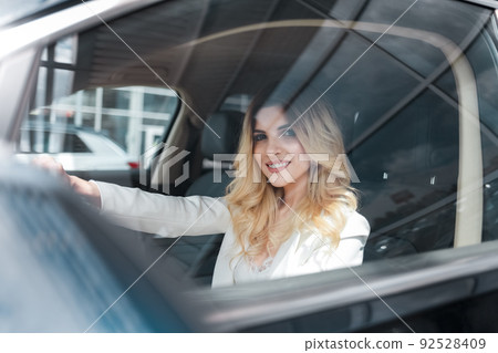 Positive beautiful woman driving an expensive car Positive beautiful woman driving an expensive car 92528409