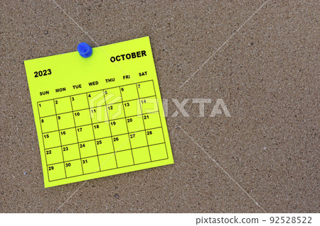 October 2023 yellow sticky note calendar with pin on cork bulletin billboard. October 2023 yellow sticky note calendar with pin on cork bulletin billboard. 92528522