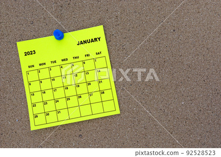 January 2023 sticky note calendar with pin on cork bulletin billboard. 92528523