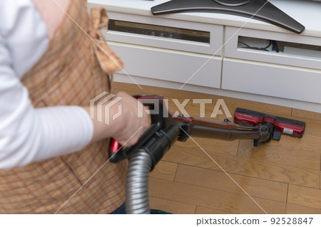 [Middle housewife cleaning flooring with a cyclone cleaner] 92528847