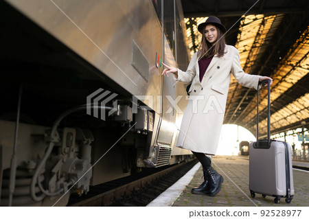 Cheerful woman presses button on the train door to enter. Railway trip concept. Cheerful woman presses button on the train door to enter. Railway trip concept. 92528977