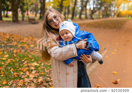Happiness mom with baby in hands in the park Happiness mom with baby in hands in the park 92530309