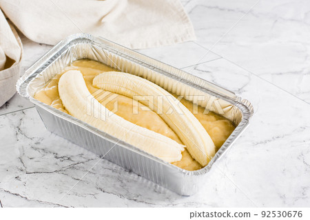 Raw dough for banana bread in a baking dish on the table. Social media trendy. Raw dough for banana bread in a baking dish on the table. Social media trendy. 92530676