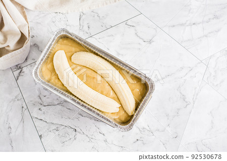Raw dough for banana bread in a baking dish on the table. Social media trendy. Top view Raw dough for banana bread in a baking dish on the table. Social media trendy. Top view 92530678