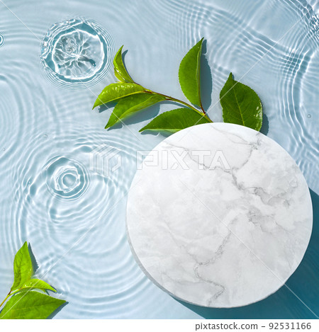 Round empty podium and tropical leaves in water with waves, splashes for presentation of natural cosmetics 92531166