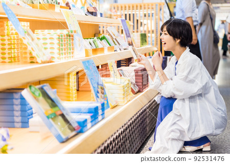 喜歡在少女之旅中挑選紀念品的年輕女性 喜歡在少女之旅中挑選紀念品的年輕女性 92531476