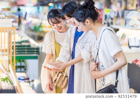 A young woman who enjoys choosing souvenirs on a girls' trip 92531479
