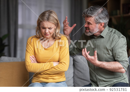 Aggressive Behavior. Portrait Of Abusive Husband Shouting At Wife At Home 92531781