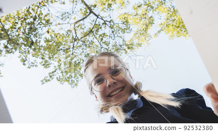 A girl opens a box in the park in admiration. 92532380