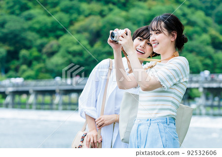 A young woman sightseeing with a camera on a girls' trip A young woman sightseeing with a camera on a girls' trip 92532606