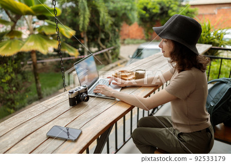 Smiling woman using laptop while working online during the journey 92533179
