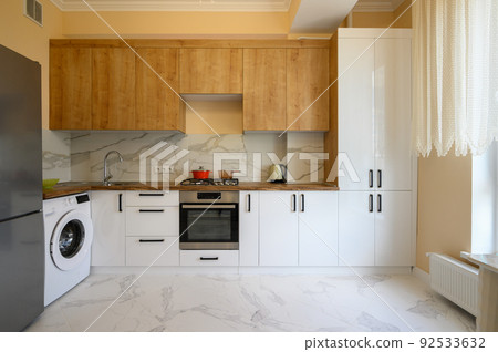 White and yellow wooden modern kitchen interior 92533632