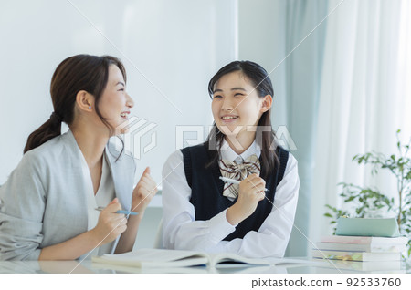 Female students receiving individual guidance at a cram school High school students Junior high school students 92533760