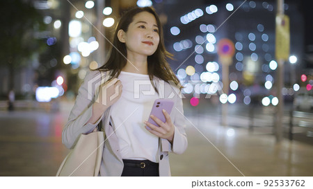 Business woman looking at a smartphone on the way home from work Female smartphone Business woman looking at a smartphone on the way home from work Female smartphone 92533762