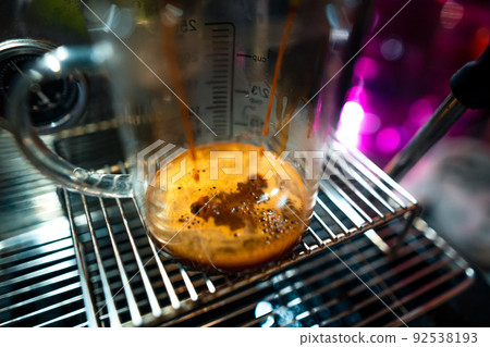 Expresso coffee dripping from the machine 92538193