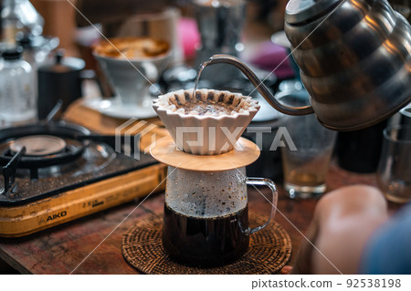 Drip coffee, barista pouring water on coffee ground with filter 92538198