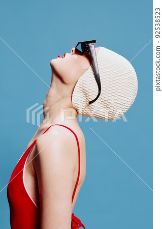 Elegant skinny stylish girl in a red swimsuit black glasses swimming cap raises her head up 92538523