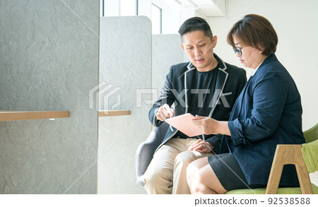 Business people talking to each other while looking at digital tablet. 92538588