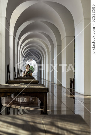 Snapshot photo woman with her camera at inside the Loha Prasart Metal Palace at Ratchanaddaram temple. 92538599