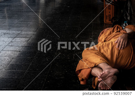 A monk is sleep on wooden chairs are waiting for trains in the area provided at Main railway station of Hua Lamphong. A monk is sleep on wooden chairs are waiting for trains in the area provided at Main railway station of Hua Lamphong. 92539007