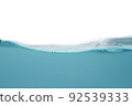 Water waves create bubbles and sludge dust in the blue water 92539333