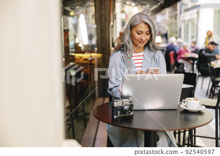 Confident Asian businesswoman networking in coffee shop 92540597